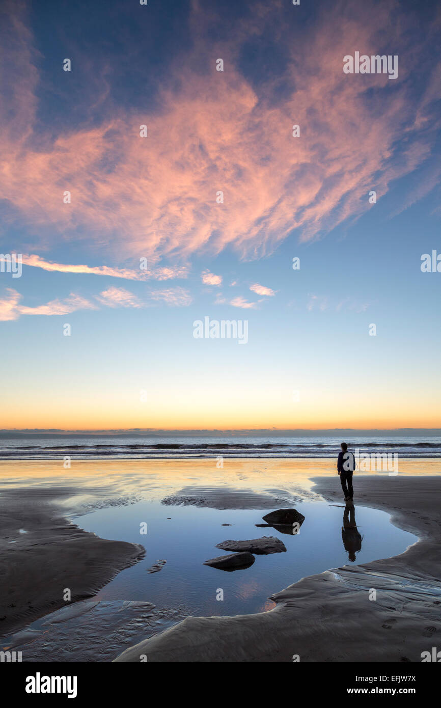 Personne debout sur la plage au coucher du soleil, Dunraven, Pays de Galles, Royaume-Uni Banque D'Images
