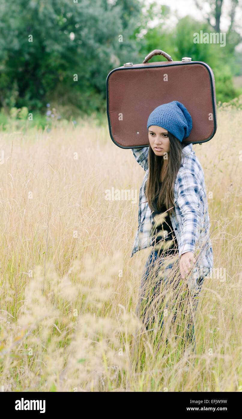 Une jeune fille avec sa valise dans la nature Banque D'Images