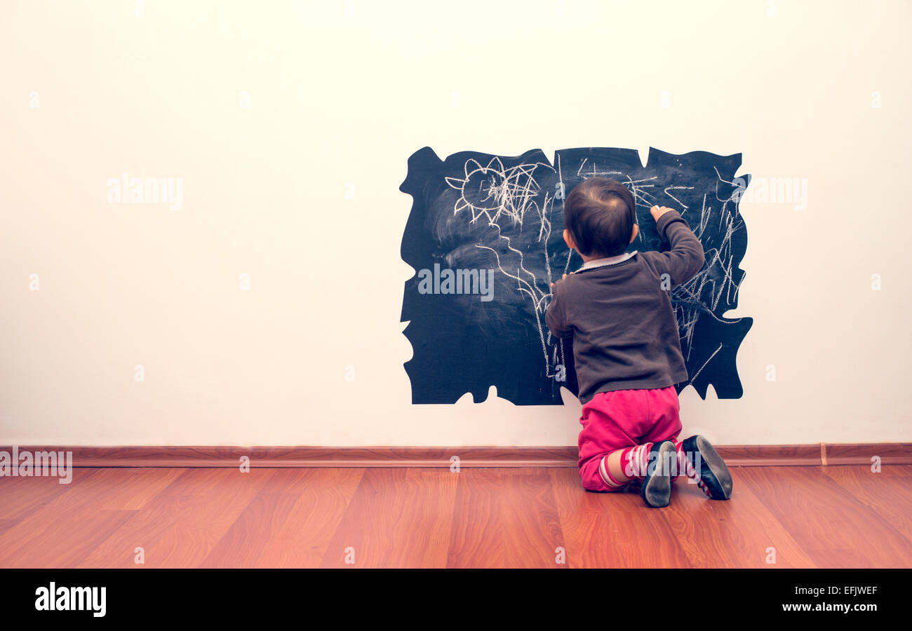 Petite fille s'appuyant sur le mur Banque D'Images