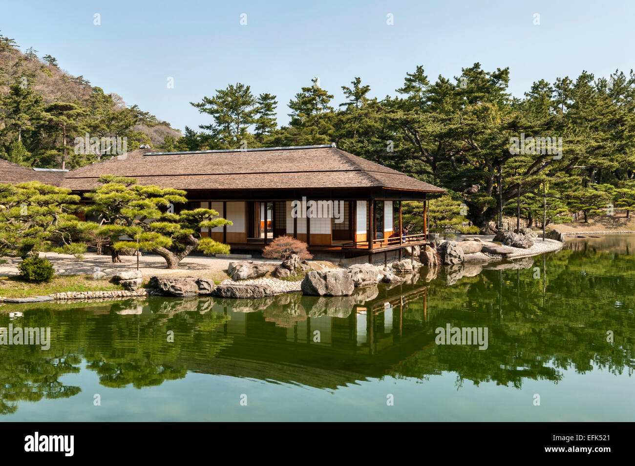 Jardin Ritsurin-koen, Takamatsu, Japon. La maison de thé Kikugetsu-tei, sur la rive du lac, avec des pins matsu-byobu (à gauche) Banque D'Images