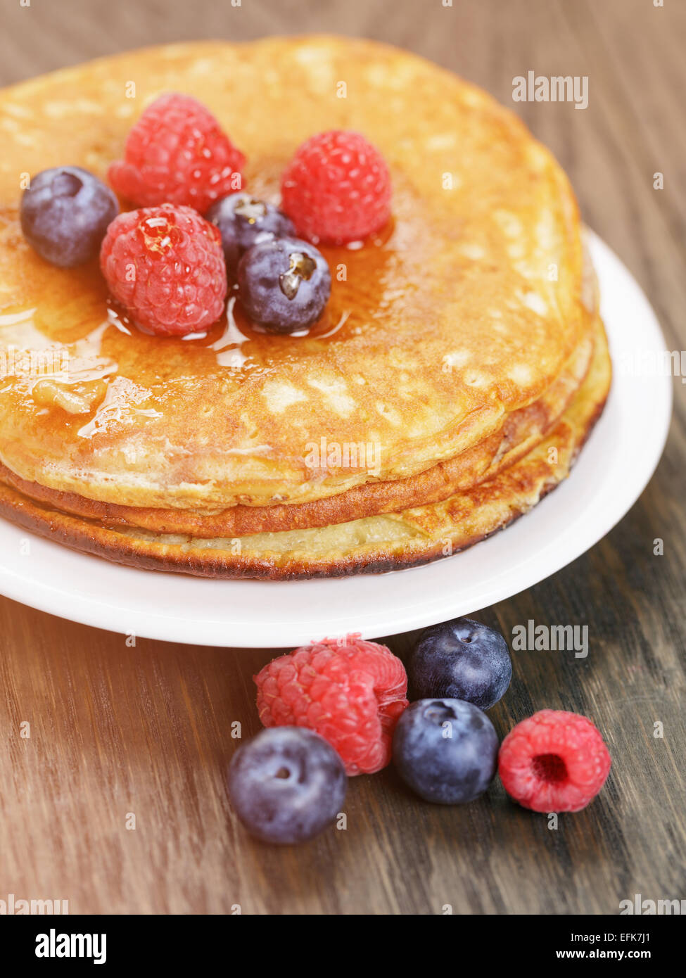 Crêpes aux fruits rouges et sirop d'érable, on wooden table Banque D'Images