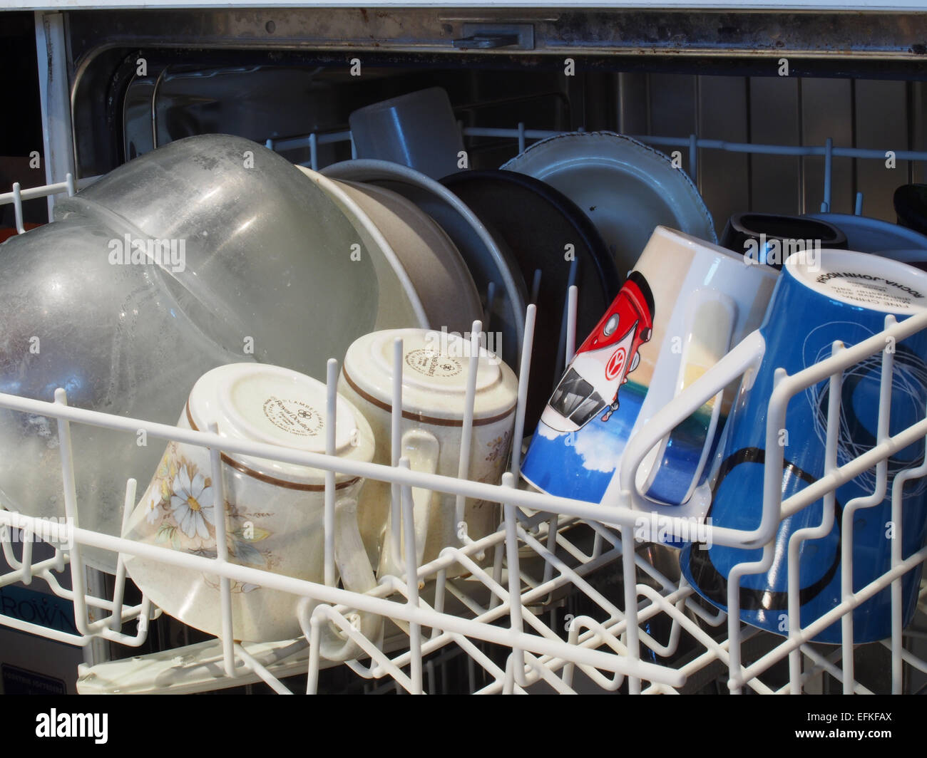 Couche supérieure d'un lave-vaisselle chargé avec les bassins et les tasses en attente d'être lavées Banque D'Images