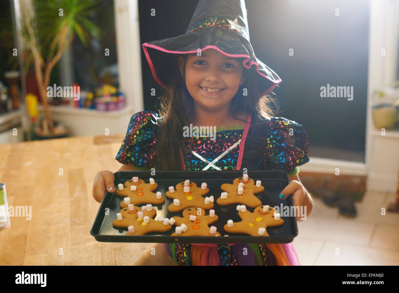 Costume halloween girl holding tray of gingerbread men Banque D'Images