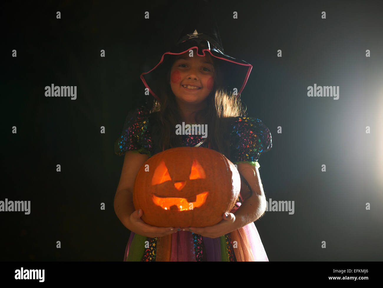 Portrait of Girl wearing costume halloween citrouille holding Banque D'Images