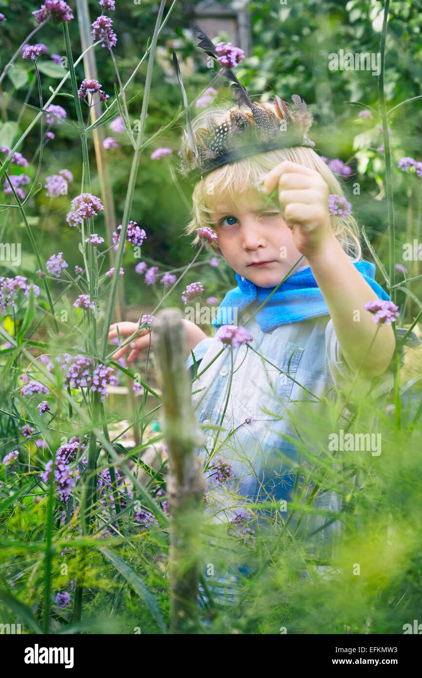 Garçon habillé et jouer avec les plantes de jardin Banque D'Images