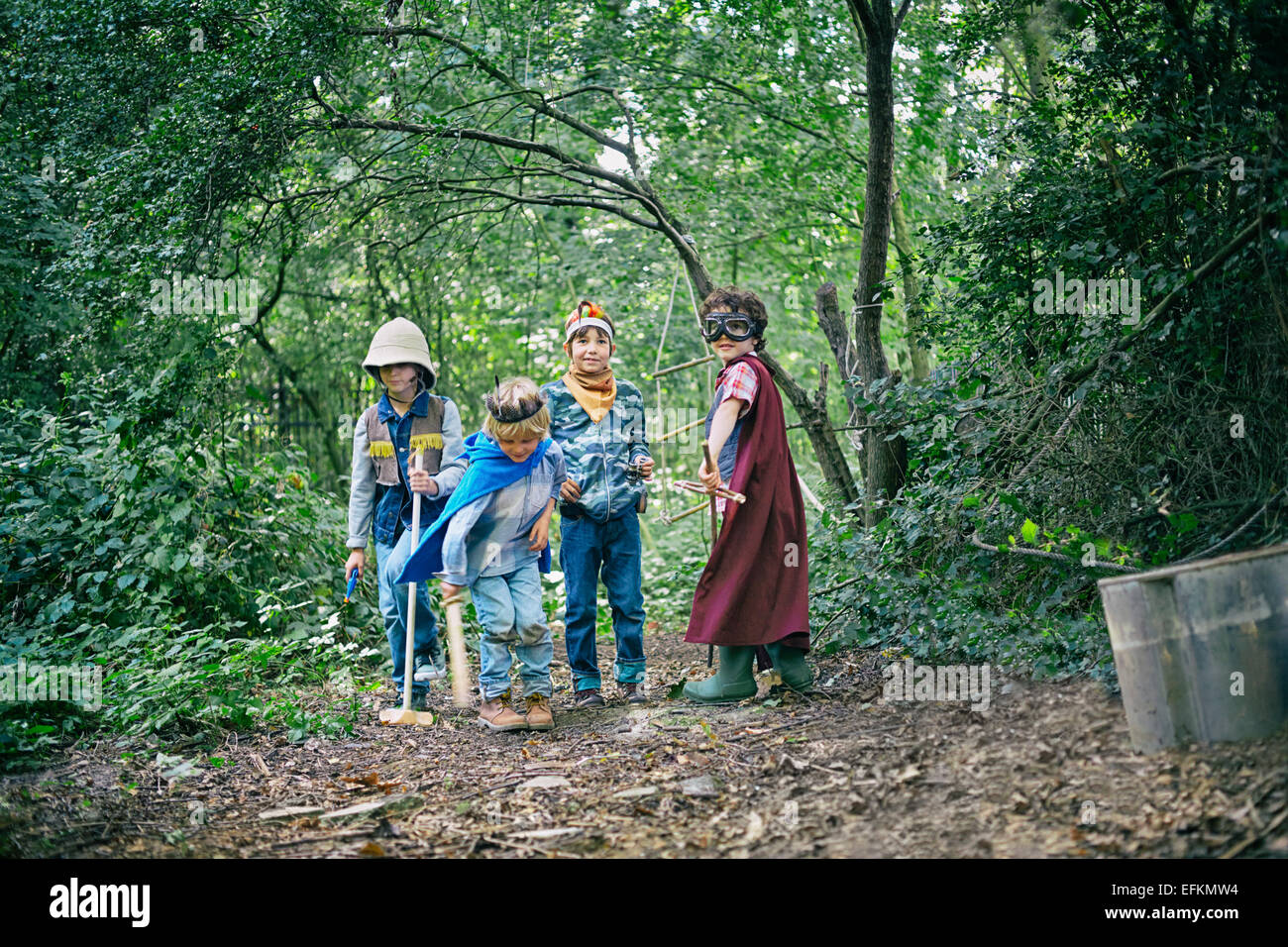 Quatre garçons habillés et jouer dans la forêt Banque D'Images