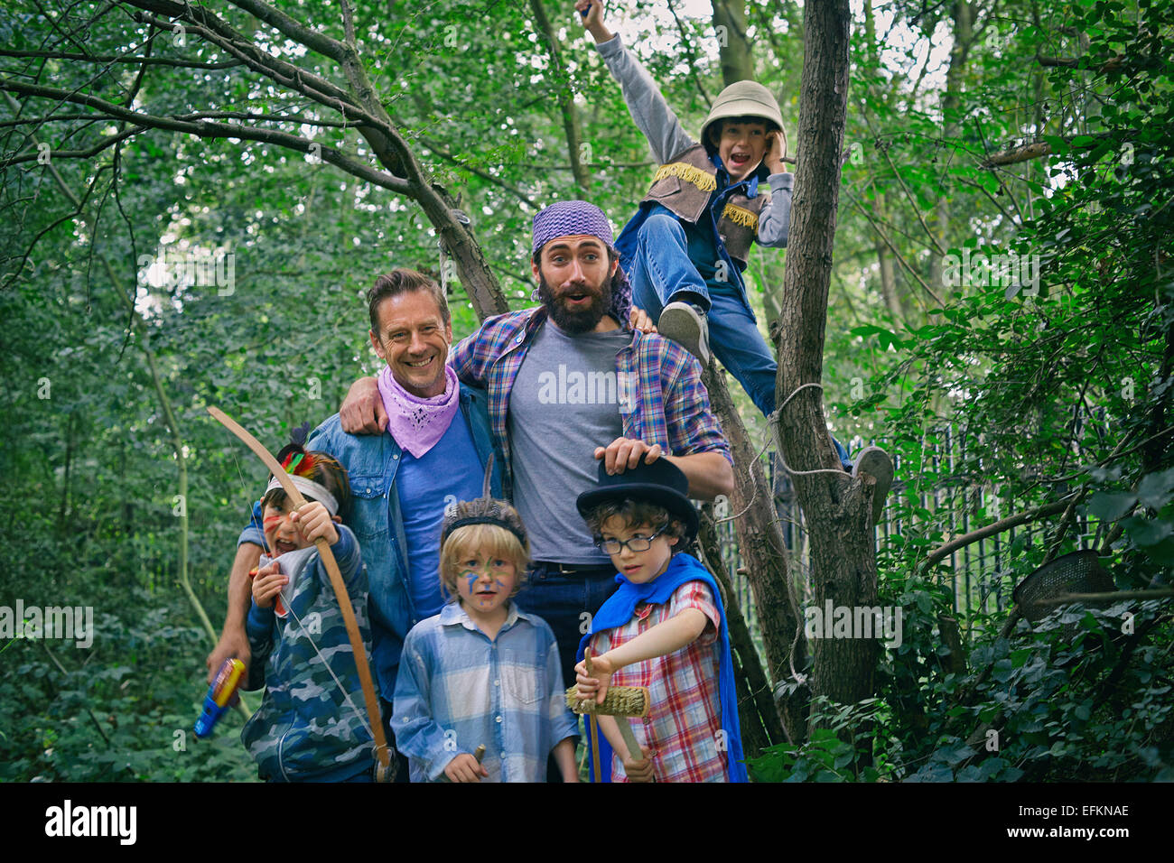 Portrait de deux hommes adultes et quatre garçons habillés en forêt Banque D'Images