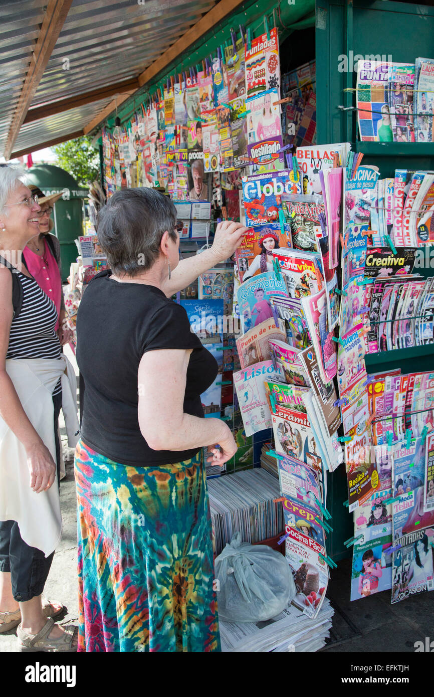 Oaxaca, Mexique - Touristes chercher des magazines dans un kiosque sur le Zócalo (place centrale). Banque D'Images