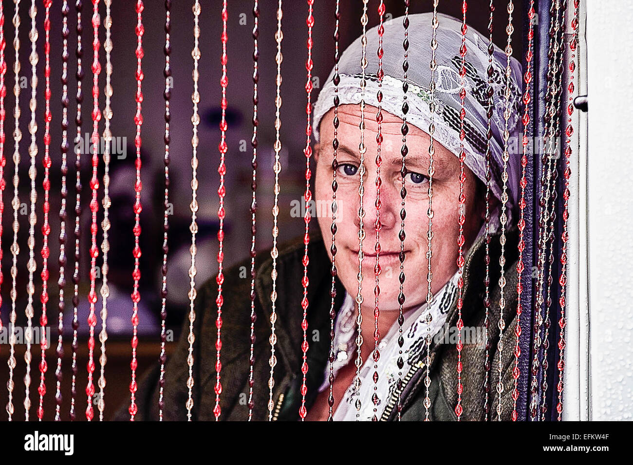 Un gypsy Fortune Teller se trouve derrière un rideau de perles dans sa caravane pendant l'attente pour les clients. Banque D'Images