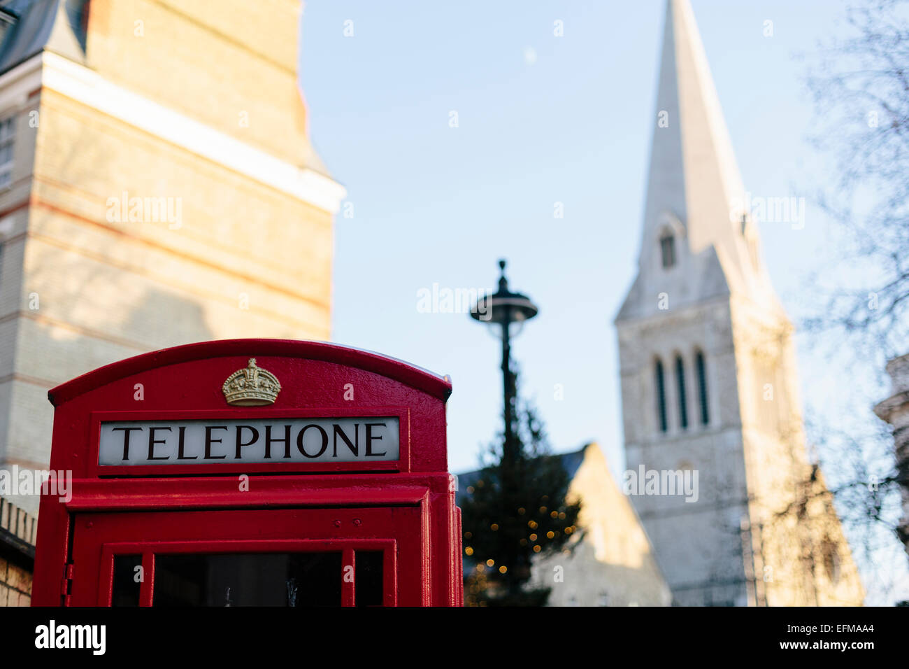 Boîte de téléphone rouge de Londres avec clocher de l'Église en arrière-plan Banque D'Images