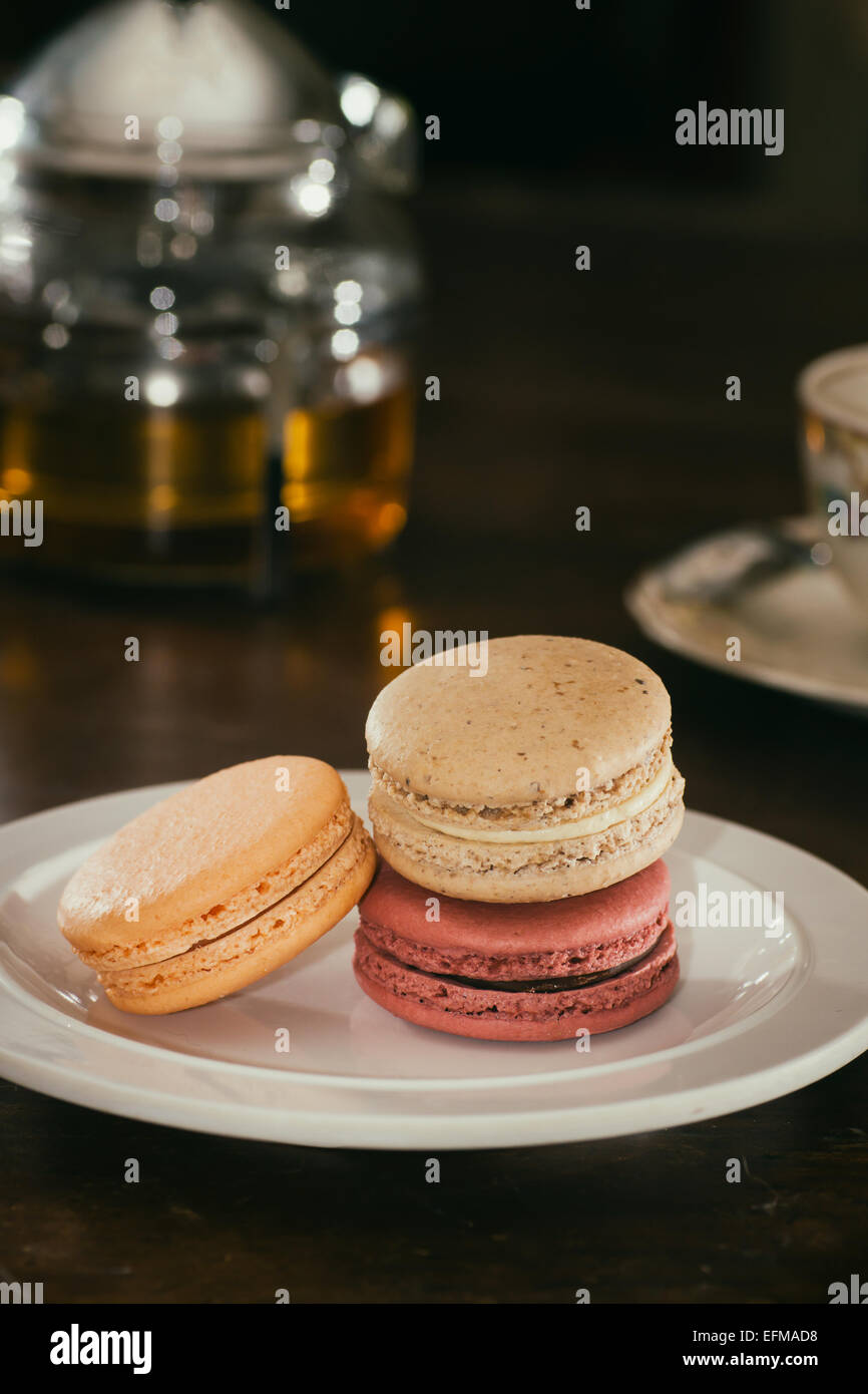 Macarons français sur une plaque avec plateau brewing à proximité. Banque D'Images