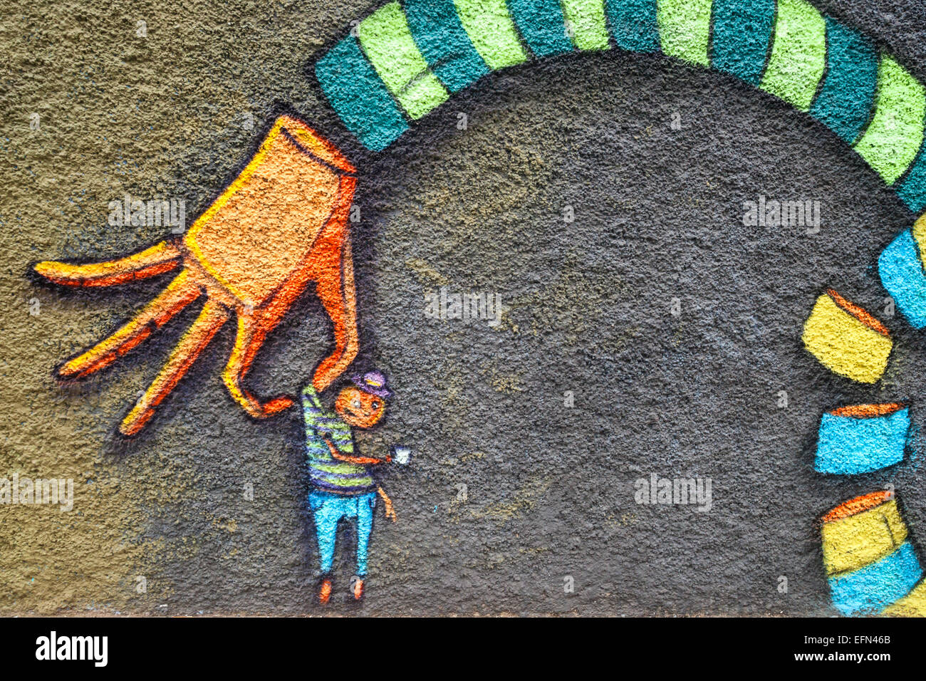 Street art mural de main tenant un petit garçon décore un bâtiment à Valparaiso, Chili, Amérique du Sud Banque D'Images