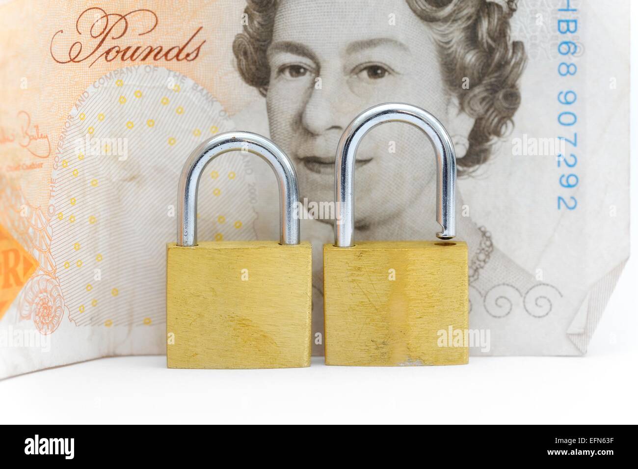 Un cadenas en laiton débloqué en face d'une note de dix livres britanniques Banque D'Images