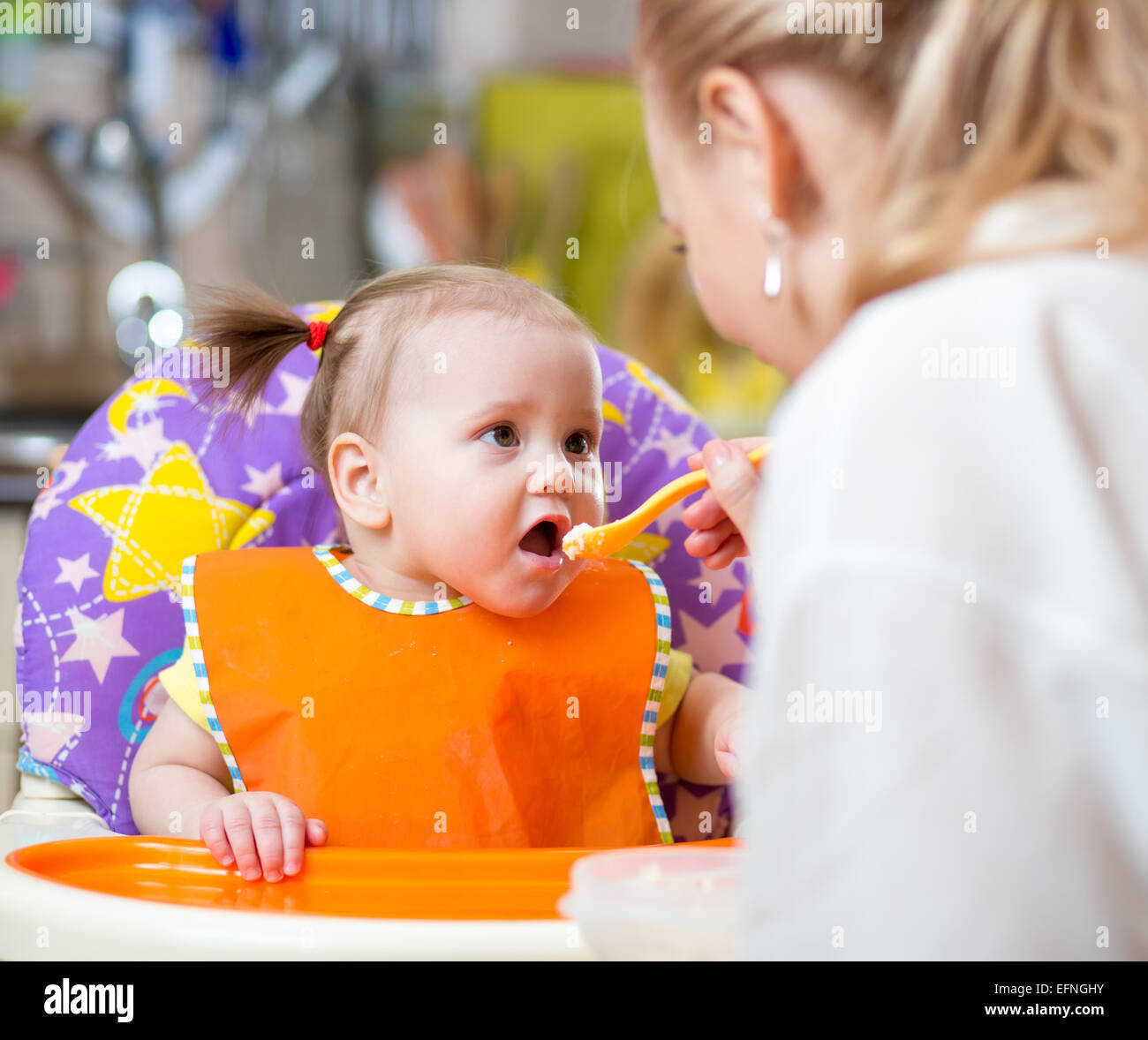 Heureux mère nourrit sa cuillère bébé enfant Banque D'Images