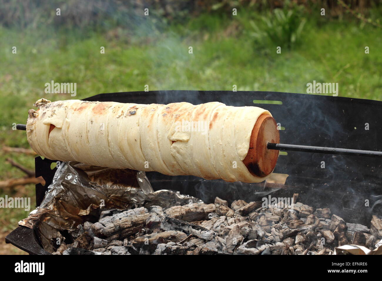 La cuisine en plein air kurtos kalacs sur feu de camp, gâteau transylvain traditionnel Banque D'Images