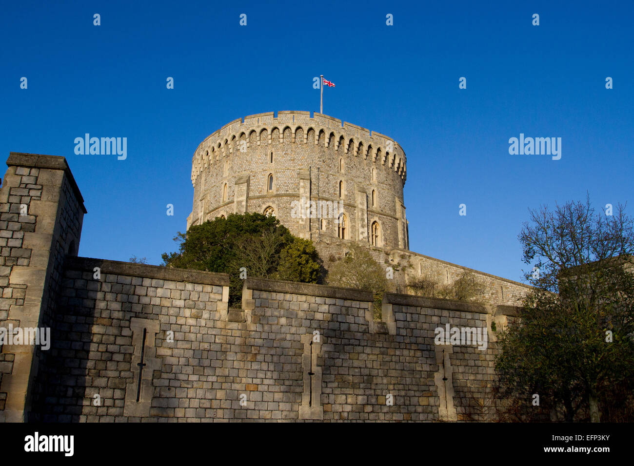 Tour ronde (la conserver) et des murs extérieurs du château de Windsor, Berkshire, Angleterre avec Union Jack en janvier vol Banque D'Images
