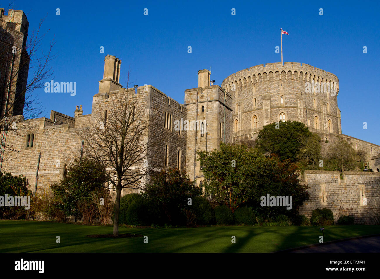 Tour ronde (la conserver) et des murs extérieurs du château de Windsor, Berkshire, Angleterre avec Union Jack en janvier vol Banque D'Images