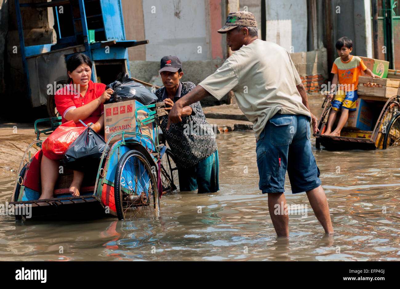 Les résidents du nord de la ville de Djakarta en passant par les marées de la mer à Muara Baru, au nord de Jakarta. Banque D'Images