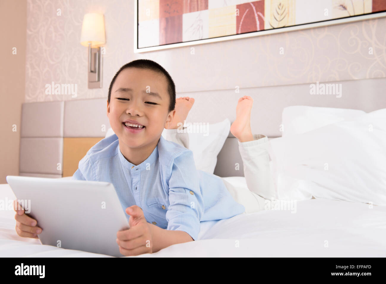 Boy using tablet in bed Banque D'Images