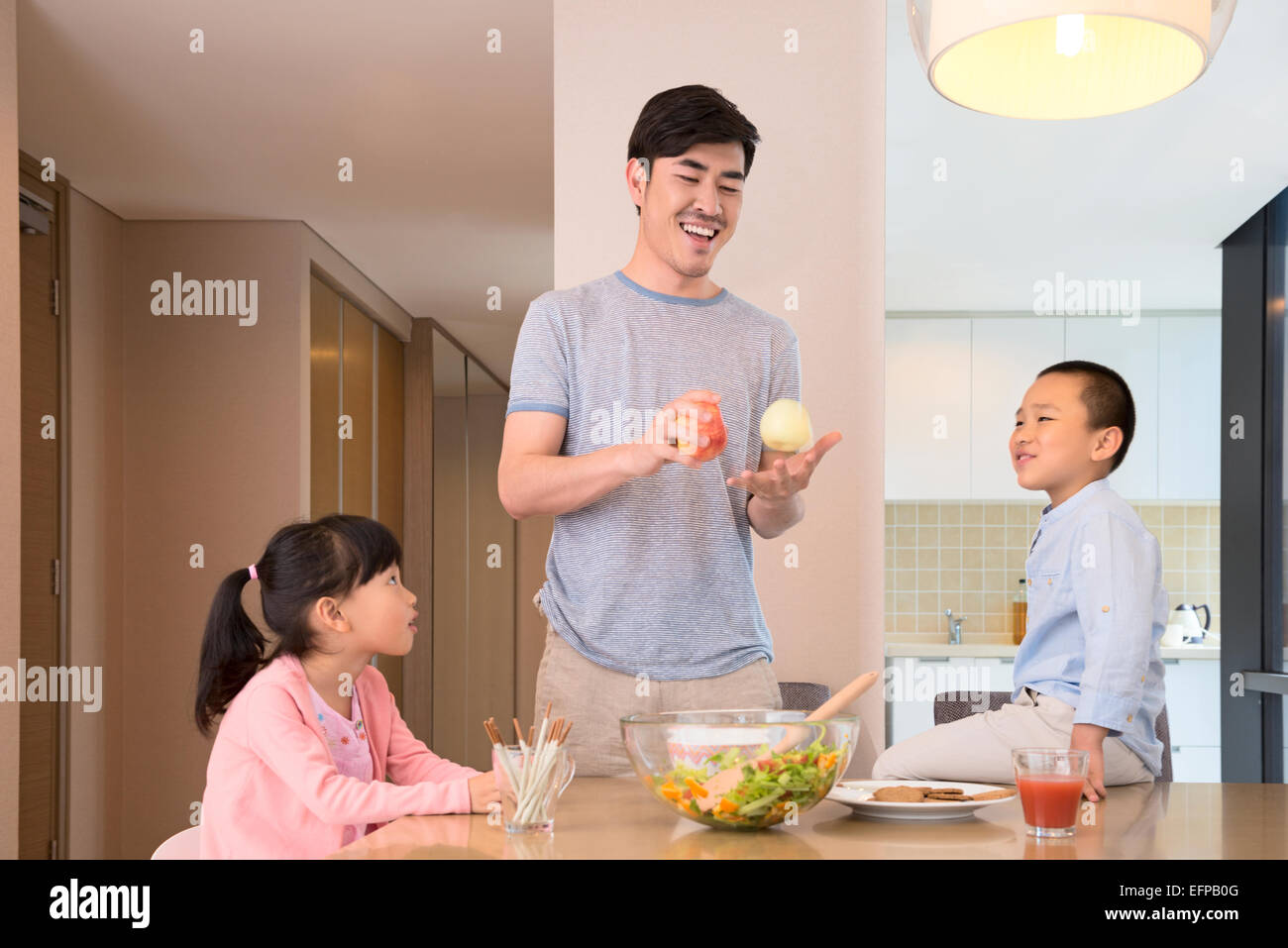 Le père et les enfants jouant dans la cuisine Banque D'Images