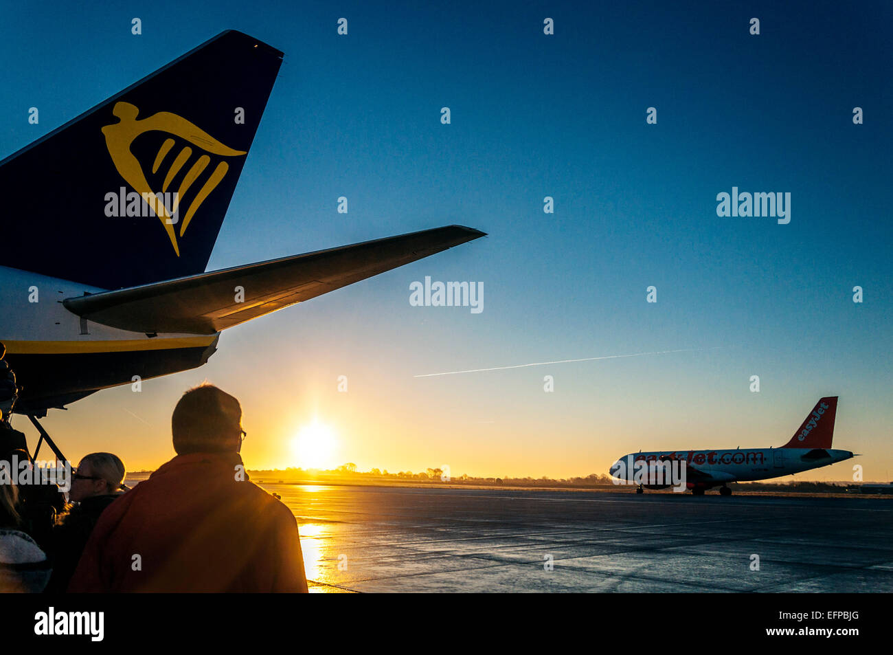 Bristol, Royaume-Uni. 9 Février, 2015. 9e février 2015. Météo britannique. L''aéroport de Bristol, Angleterre. Les passagers d'un vol Ryanair pour Dublin au lever du soleil comme un avion Easyjet taxis. Crédit : Richard Wayman/Alamy Live News Banque D'Images