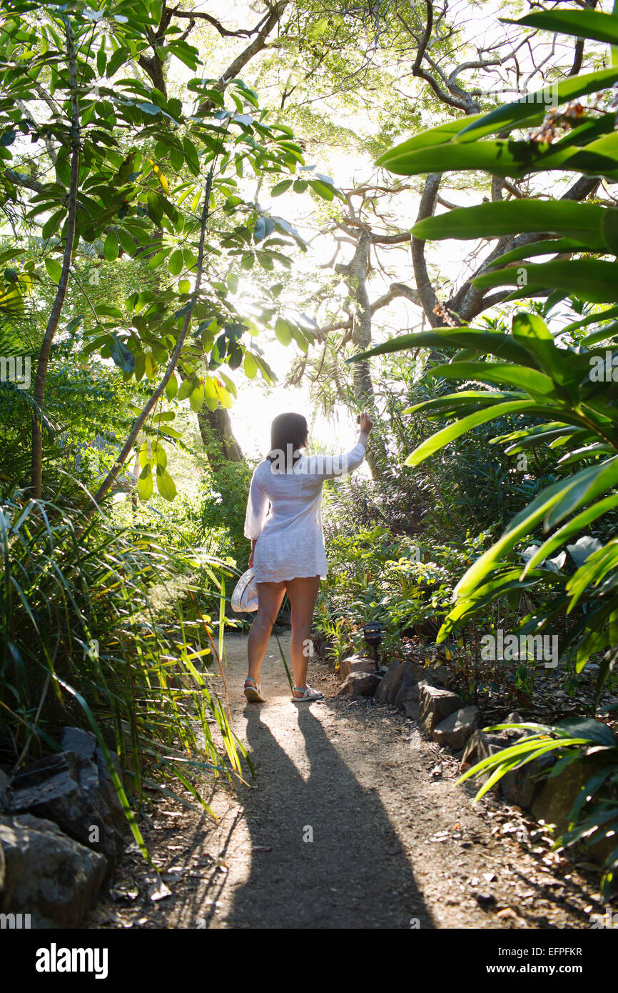 Vue arrière du couple à la découverte des jardins tropicaux sur Long Island, Whitsunday Islands, Queensland, Australie Banque D'Images
