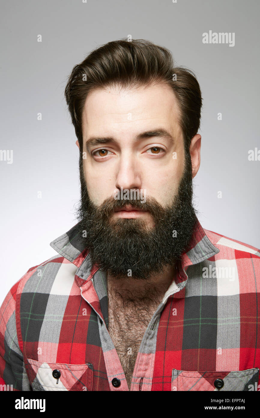 Studio portrait de jeune homme barbu à l'écart Banque D'Images