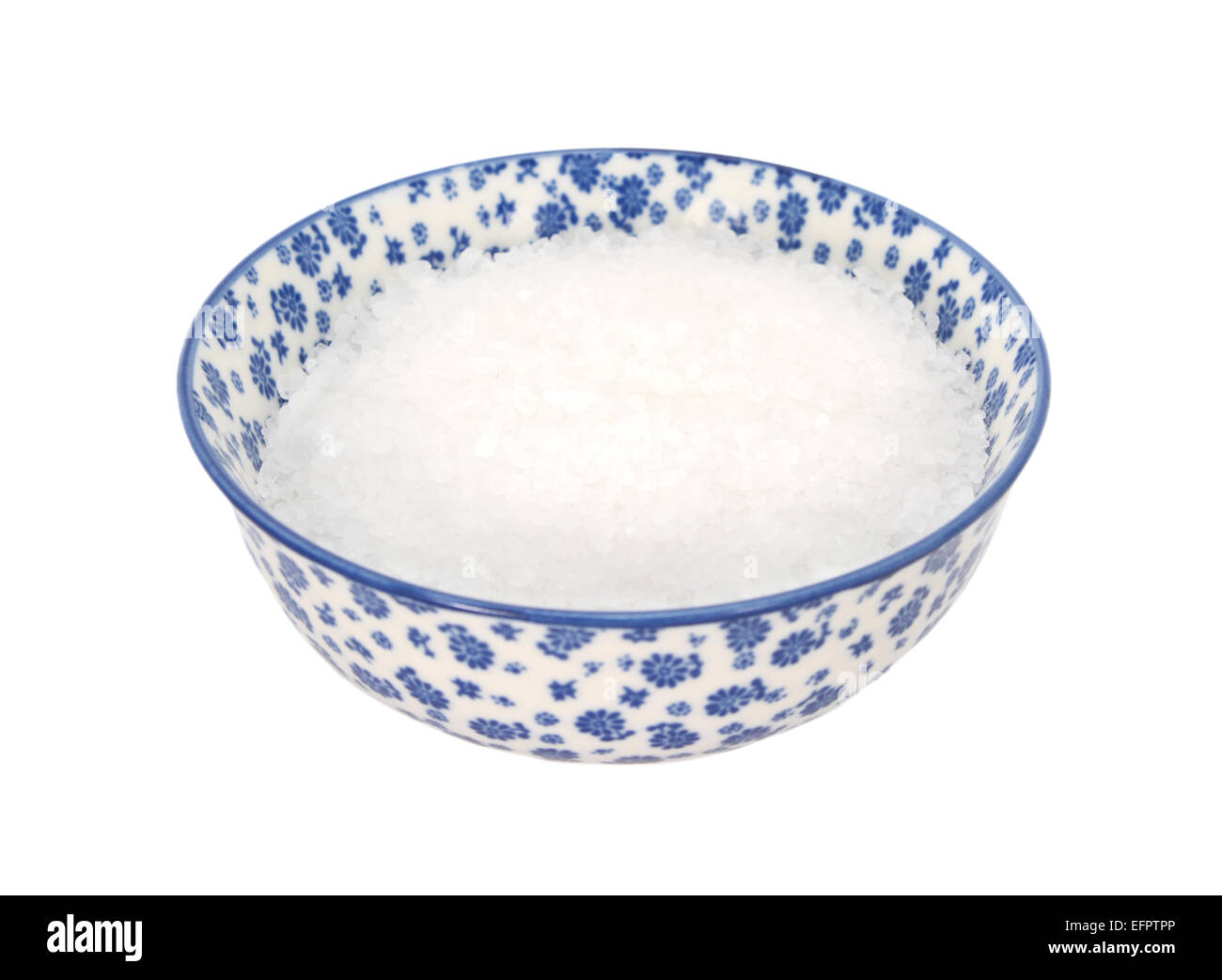 Gros sel de mer dans un bol en porcelaine bleu et blanc avec un design floral, isolé sur fond blanc Banque D'Images