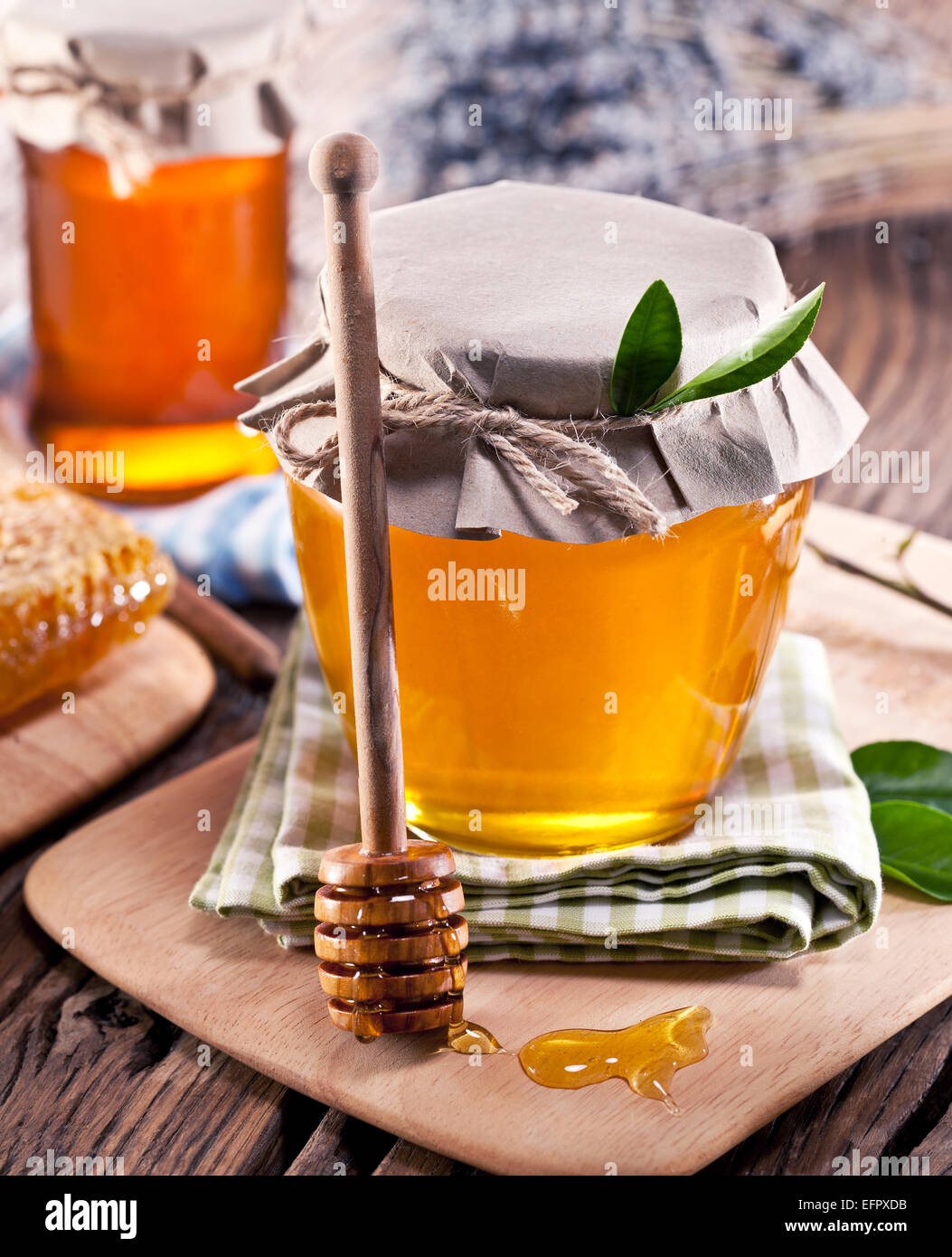 Les canettes en verre pleine de miel sur vieille table en bois. Banque D'Images