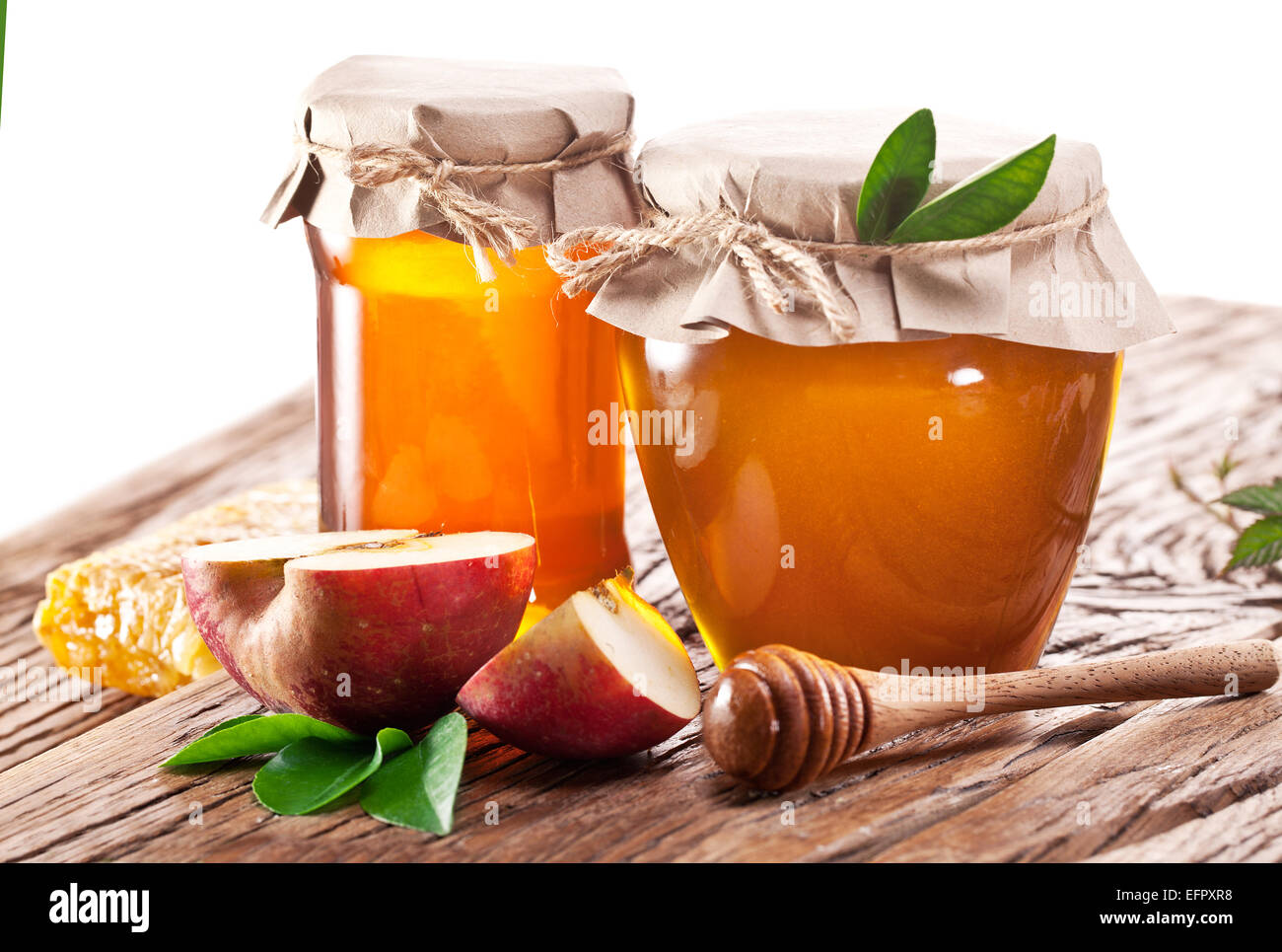 Les canettes en verre plein de miel et de pomme sur l'ancienne table en bois. Banque D'Images