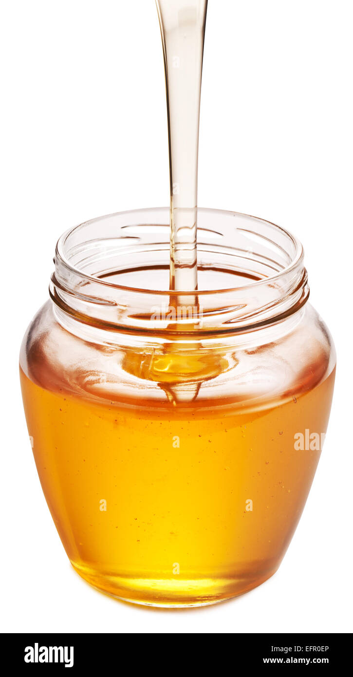 Le miel qui coule dans le verre peut. Fichier contient des chemins de détourage. Banque D'Images