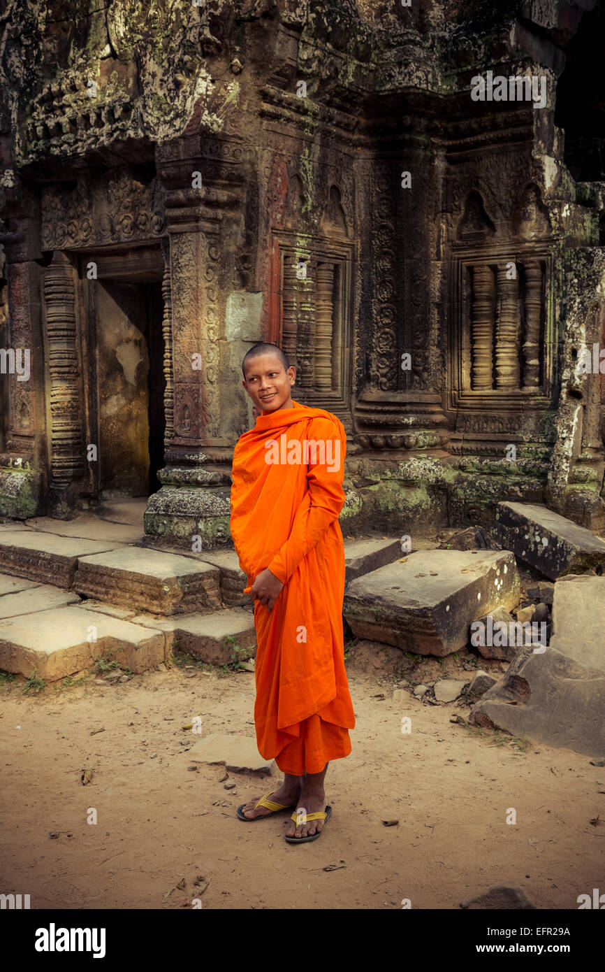 Le moine bouddhiste dans les ruines du Temple Ta Prohm, l'Angkor, au Cambodge. Banque D'Images