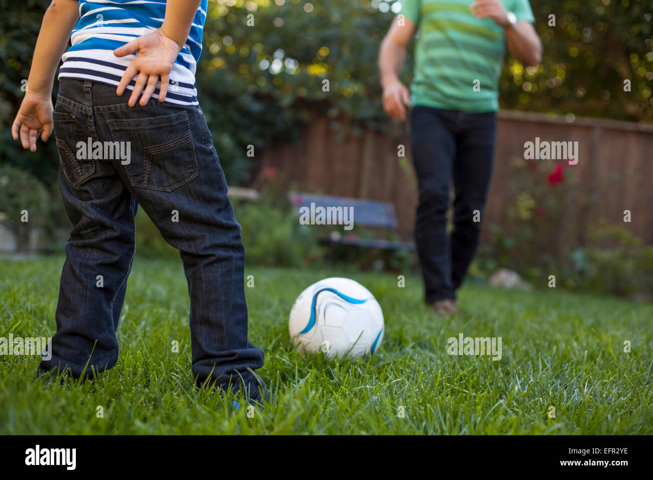 Père et fils à jouer au football dans le jardin Banque D'Images