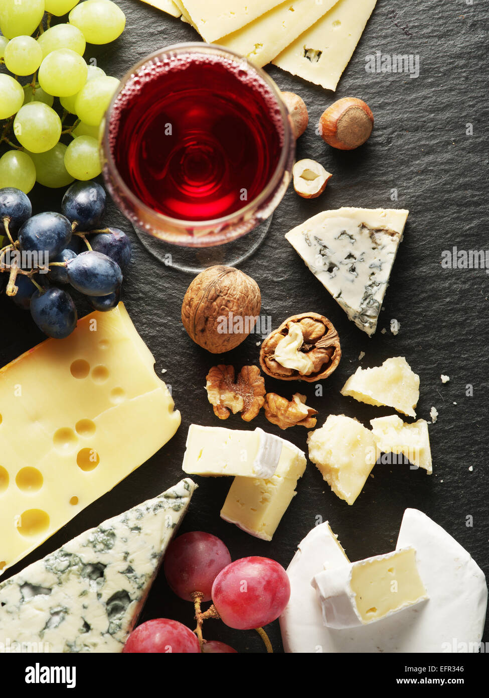 Différents types de fromages avec un verre de vin et de fruits. Vue d'en haut. Banque D'Images