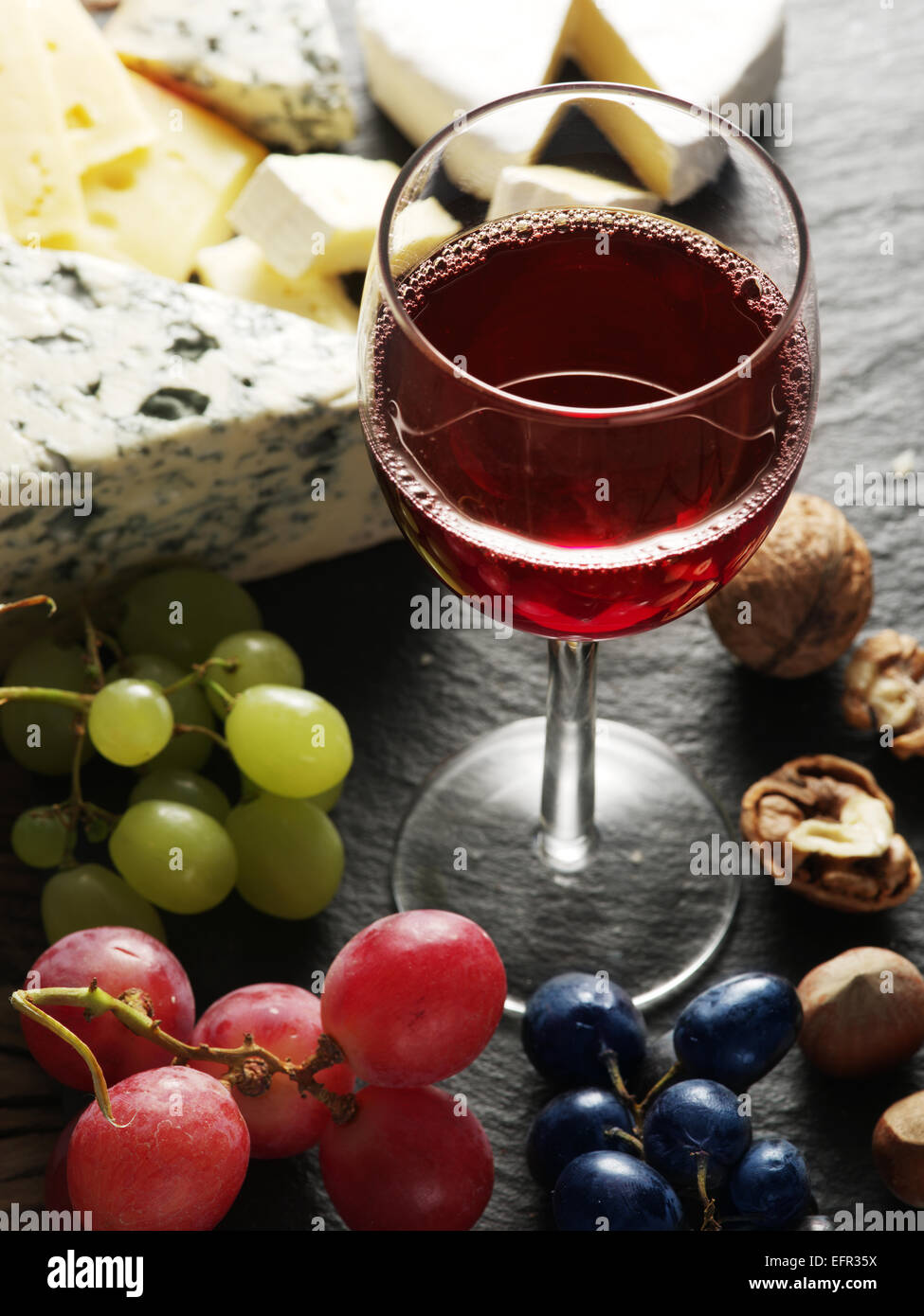 Différents types de fromages avec un verre de vin et de fruits. Banque D'Images