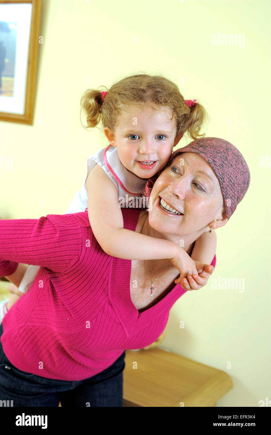 Une femme s'amuser avec sa fille. Elle porte un bandeau en raison d'un traitement de chimiothérapie pour une leucémie. Banque D'Images