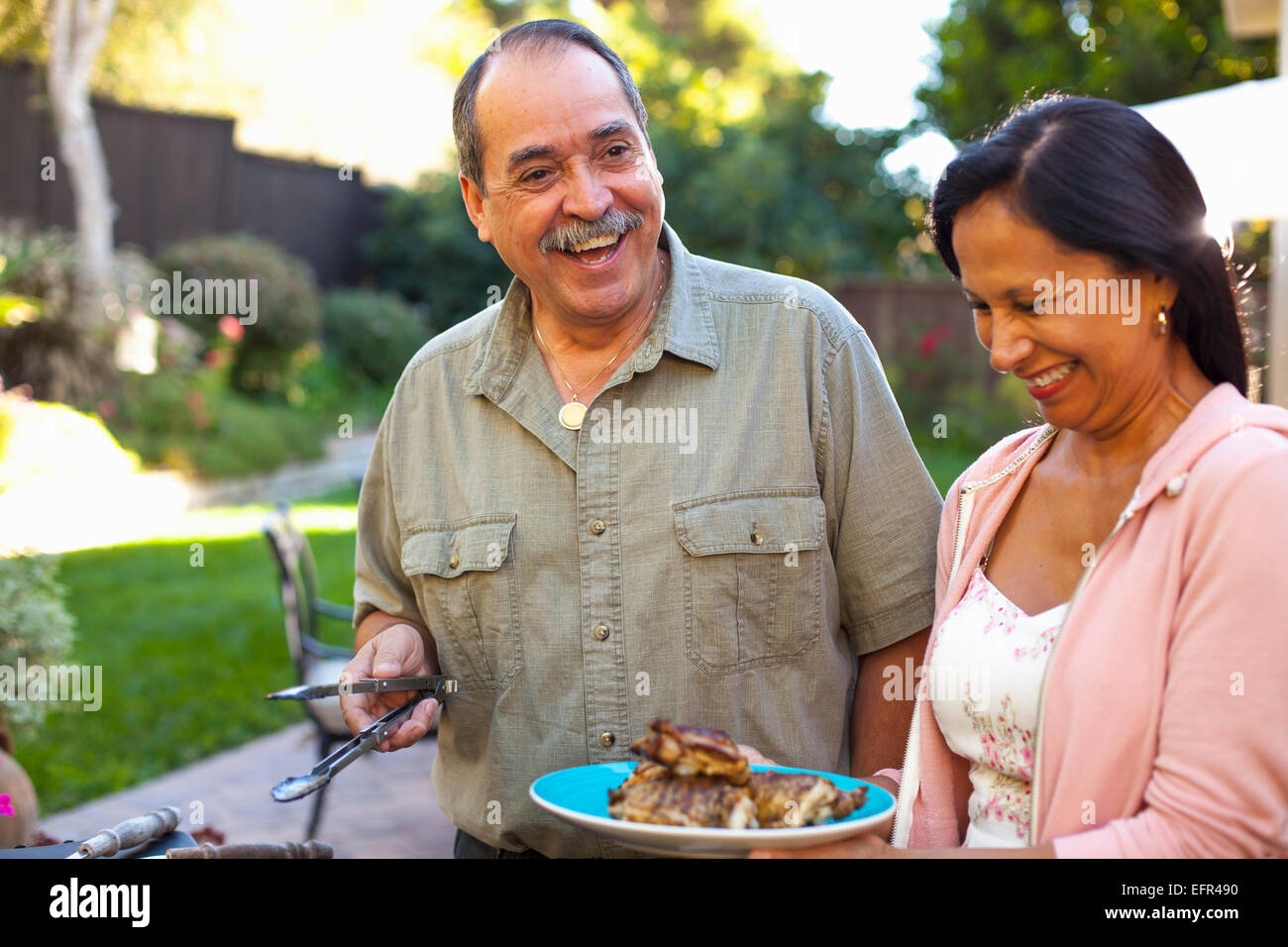 Mari et femme au barbecue dans le jardin Banque D'Images