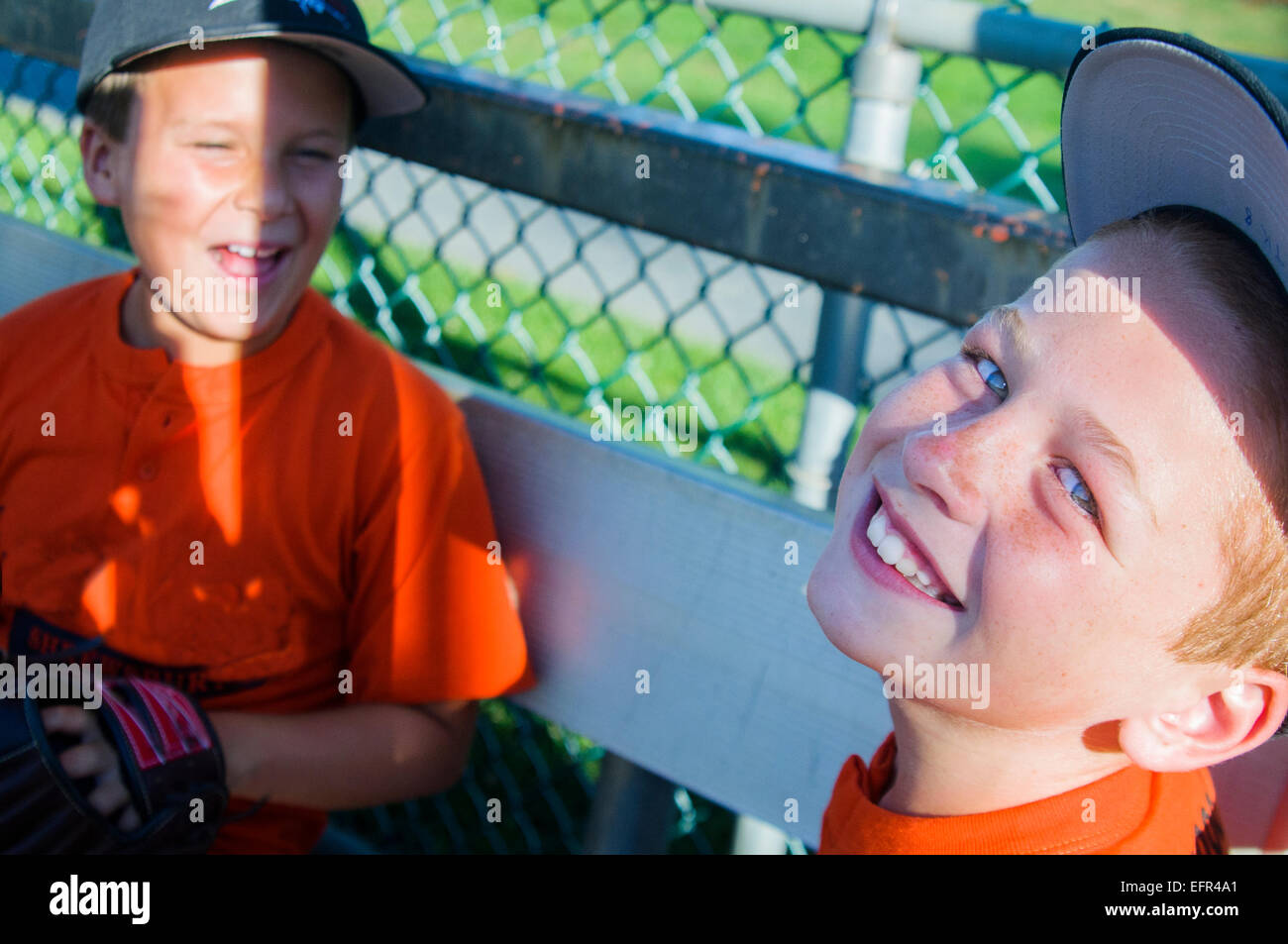 Deux jeunes joueurs de baseball masculin rire ensemble Banque D'Images