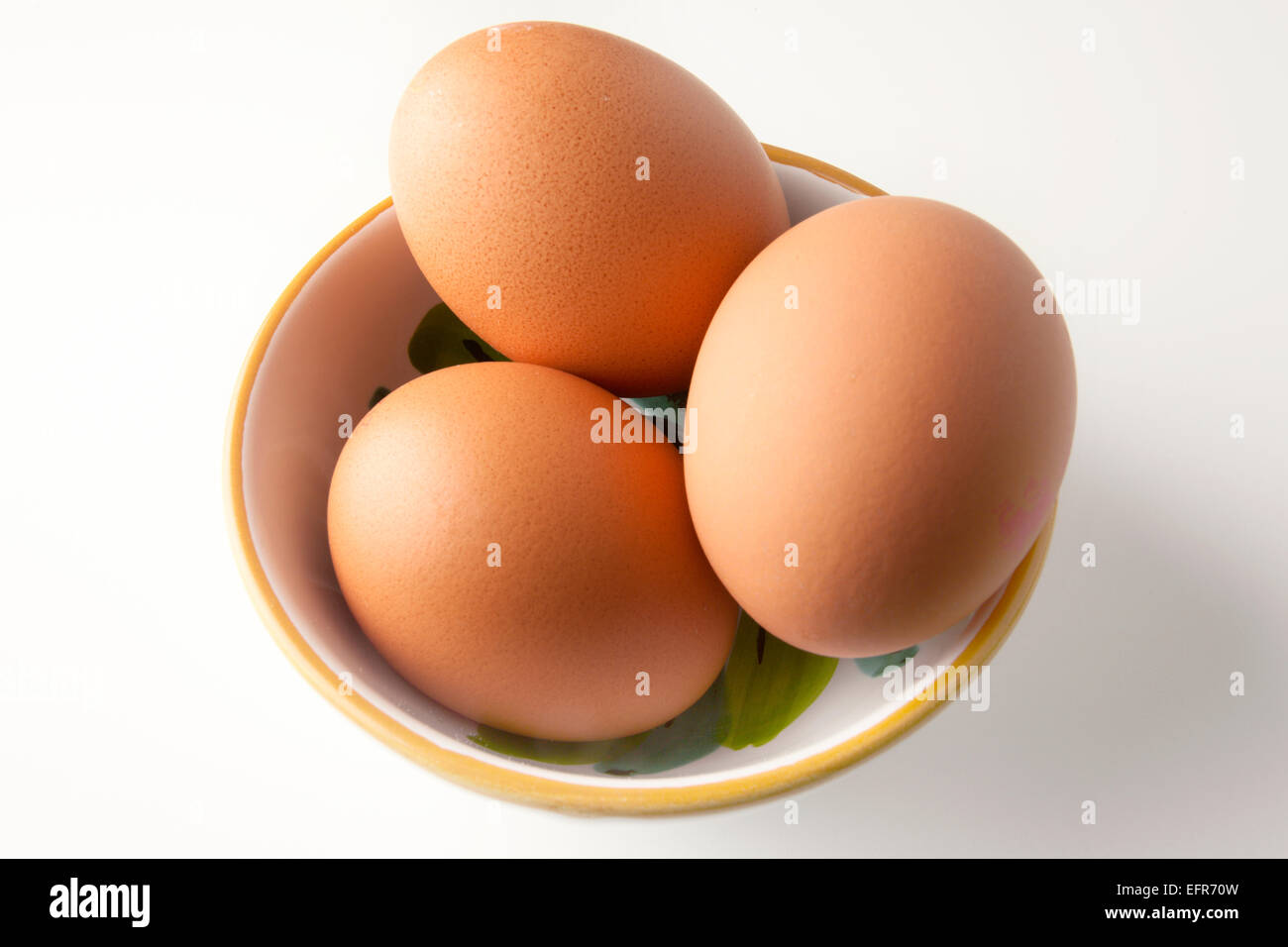 Trois poules en libre parcours brun oeufs dans un petit bol Banque D'Images