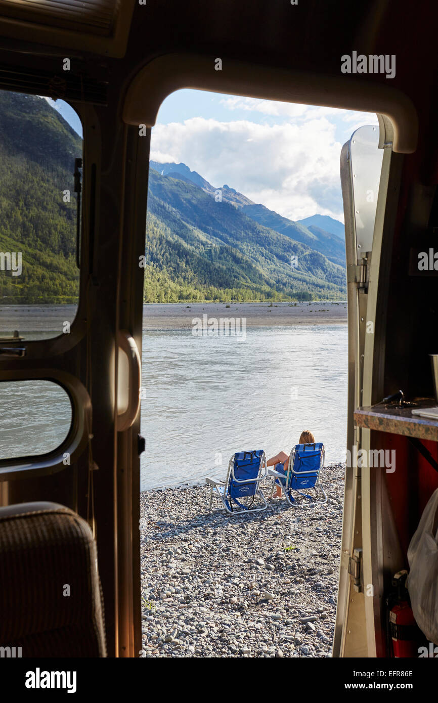 Vue depuis le camping-car porte de Mid adult woman sitting by lake, Palmer, Alaska, USA Banque D'Images