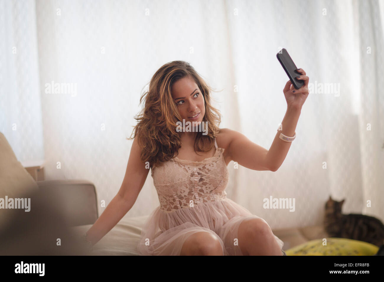 Woman Sexy smartphone prendre sur selfies salon canapé Banque D'Images