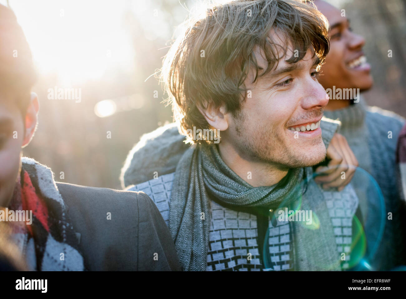 Deux hommes souriant debout dans une forêt ensoleillée à l'automne. Banque D'Images