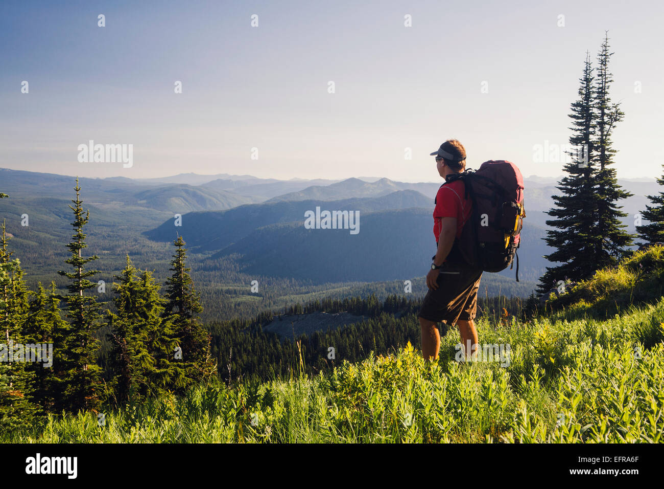 Homme randonnée en montagne, marche sur une crête surplombant une vallée. Banque D'Images