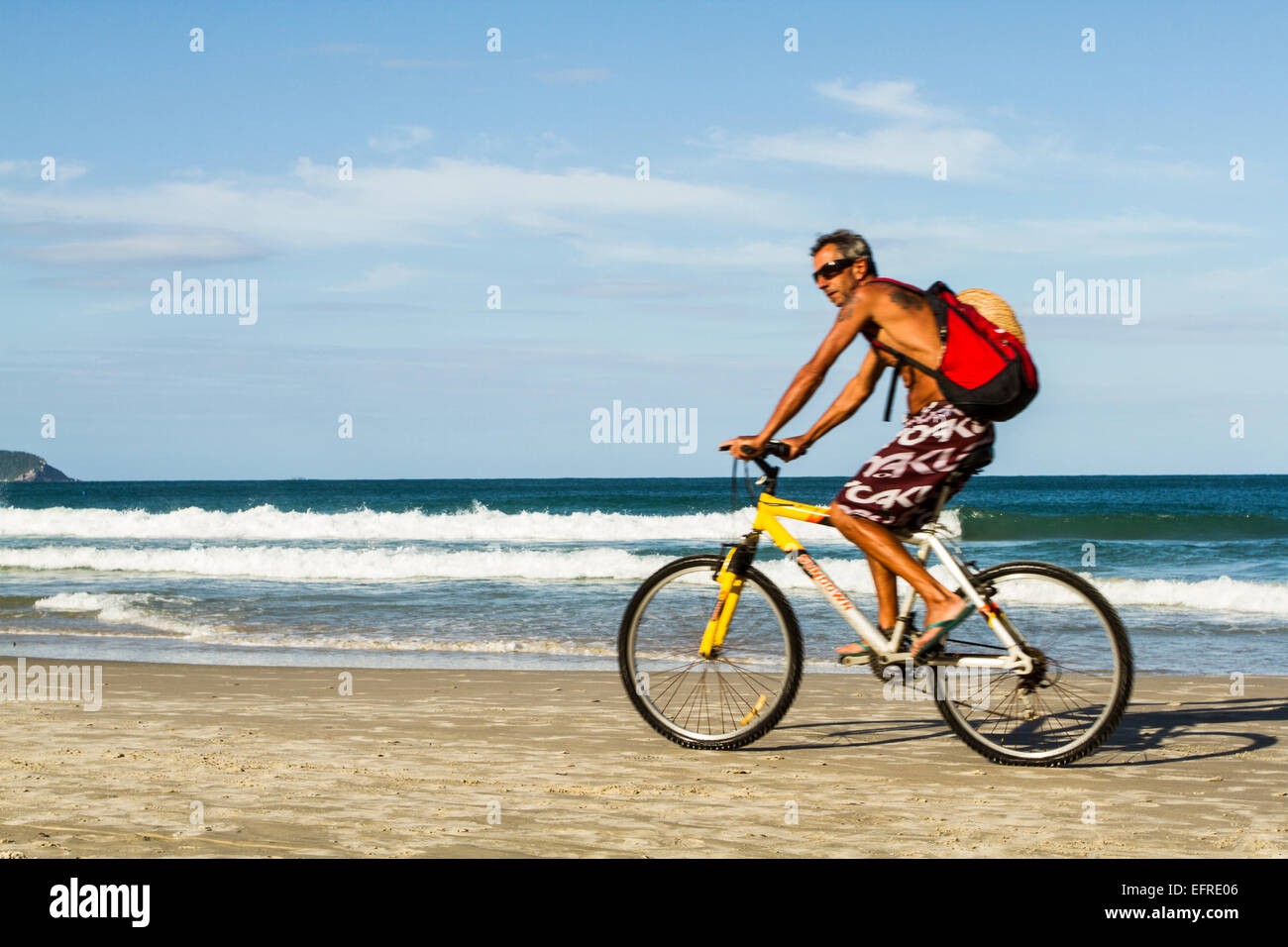 Homme monté sur un vélo à Matadeiro Beach. Florianopolis, Santa Catarina, Brésil. Banque D'Images