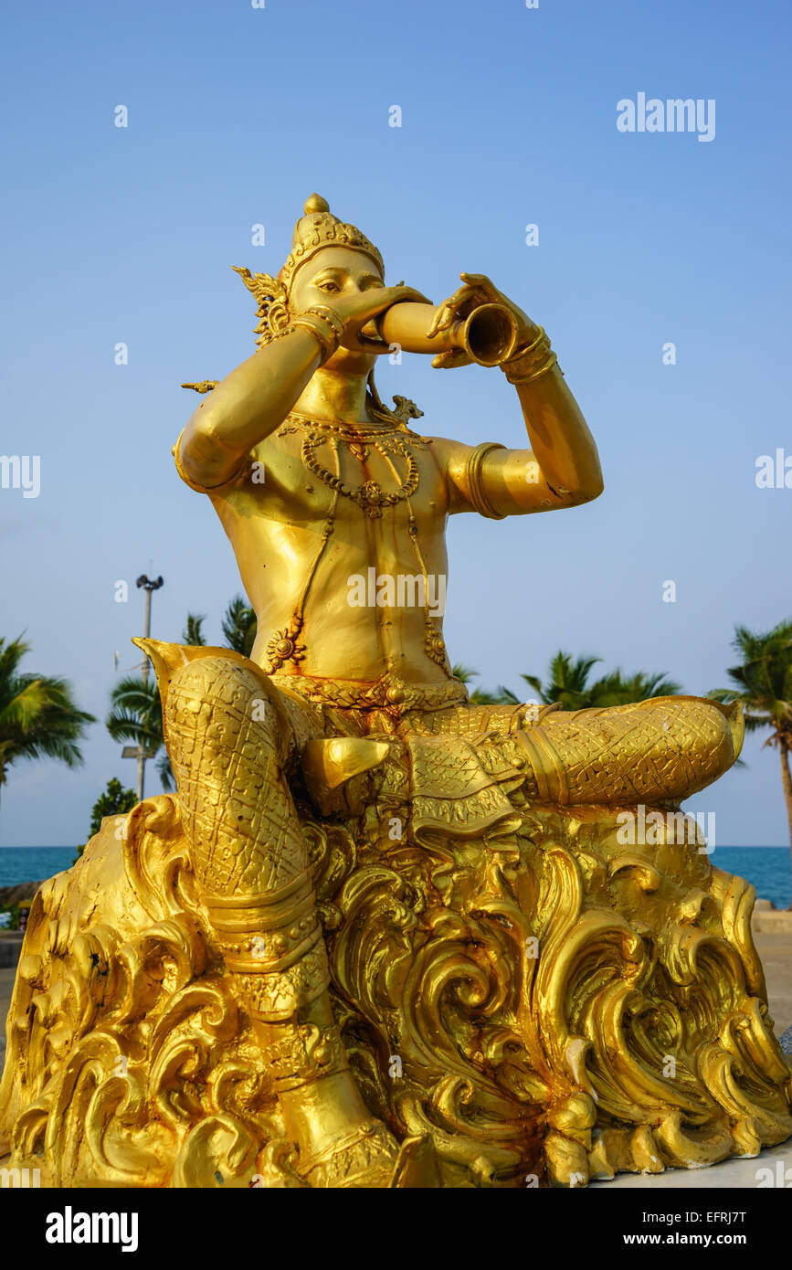 Statue en or de Phra Aphai Mani Roi soufflant sa pipe par la mer. Banque D'Images