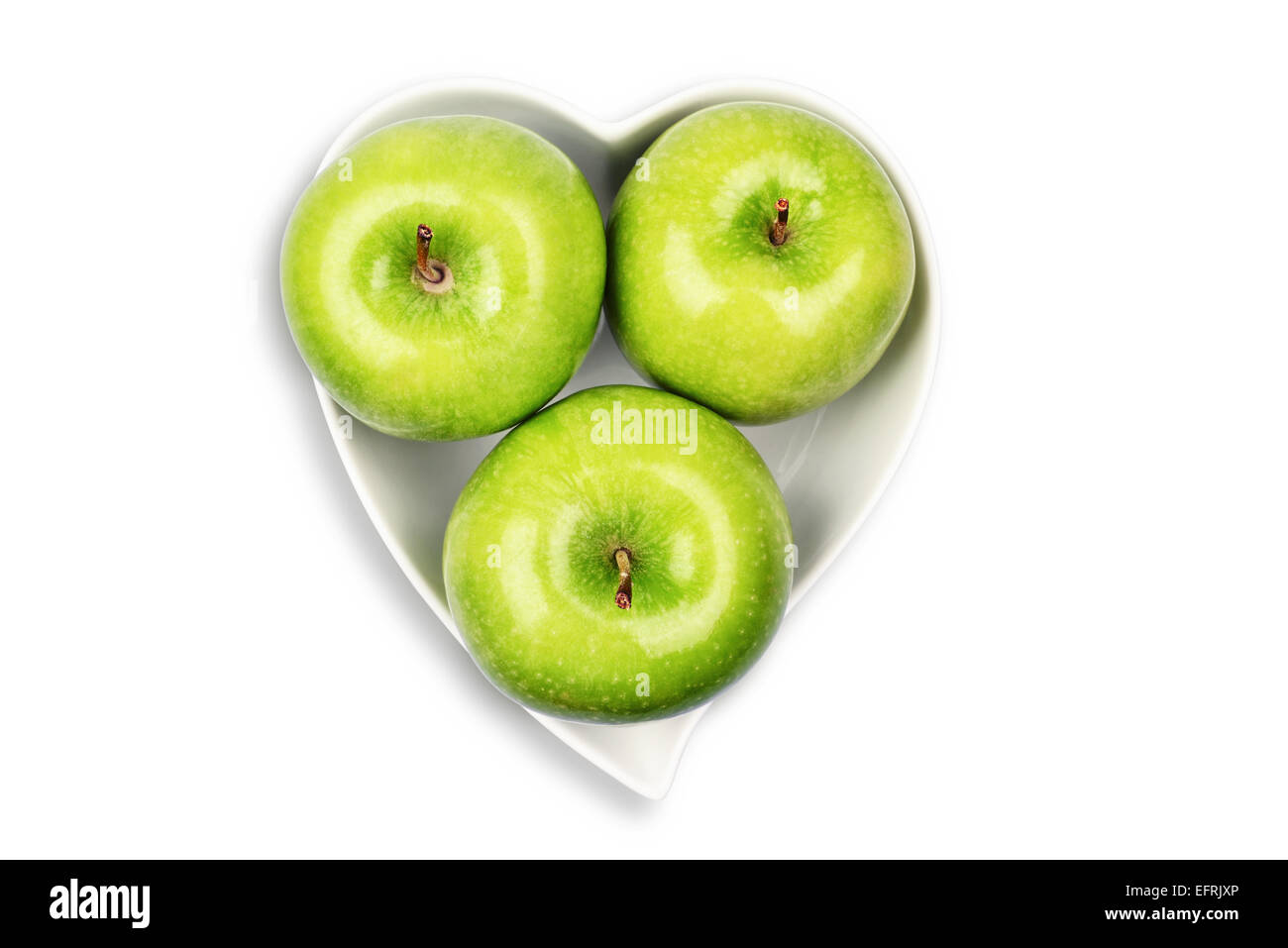 Green Apple sur bol en forme de coeur Banque D'Images