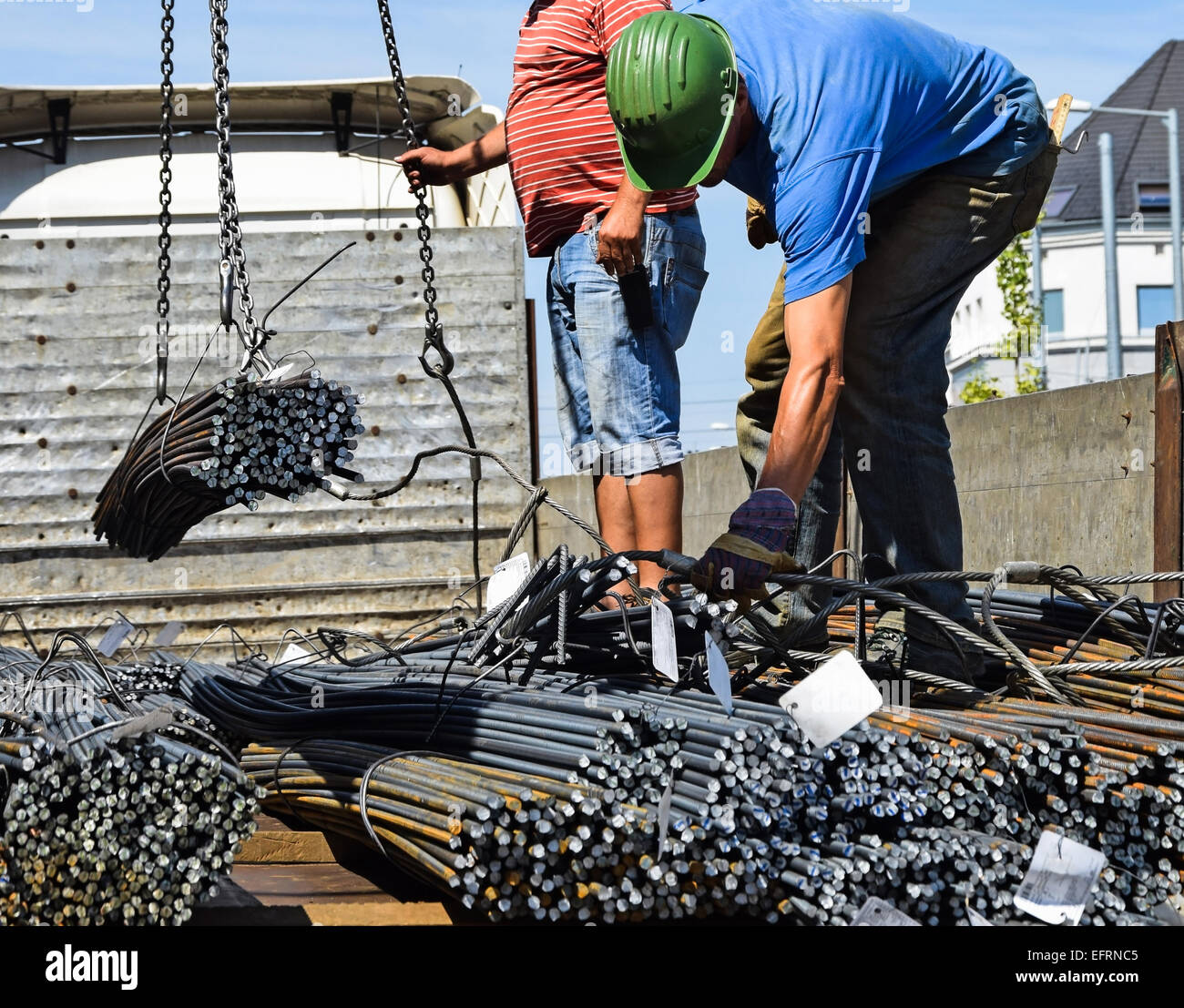 Les travailleurs de la construction du déchargement d'un camion avec des barres de fer Banque D'Images