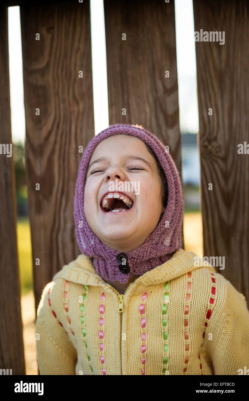Jeune fille riant portant chapeau tricoté et sweater Banque D'Images