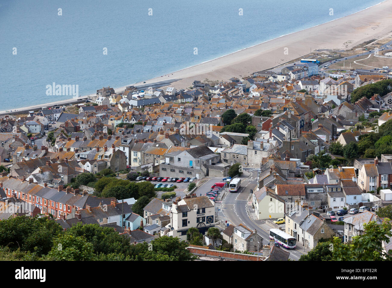 Vue depuis le sommet de Portland dirigez-vous vers le bas sur dense Logement urbain de style ancien et vers l'ouest le long de Chesil Beach Banque D'Images