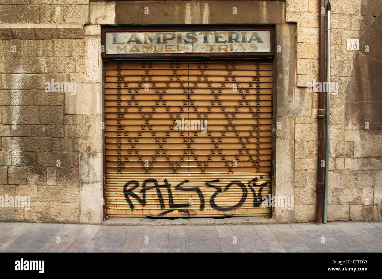 Ancien atelier d'électricité (lampisteria) avec obturateur fermé et graffiti dans la vieille ville de Gérone, Catalogne, Espagne Banque D'Images